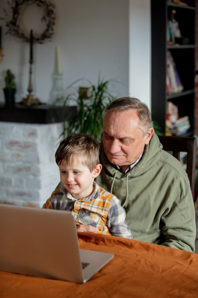 little boy and grandfather using laptop computer